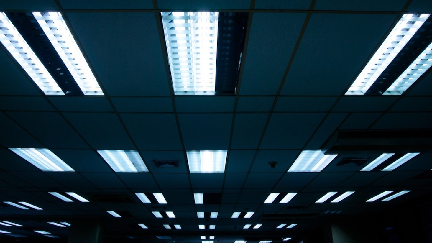 What is a ballast factor and how does it affect fluorescent tubes?